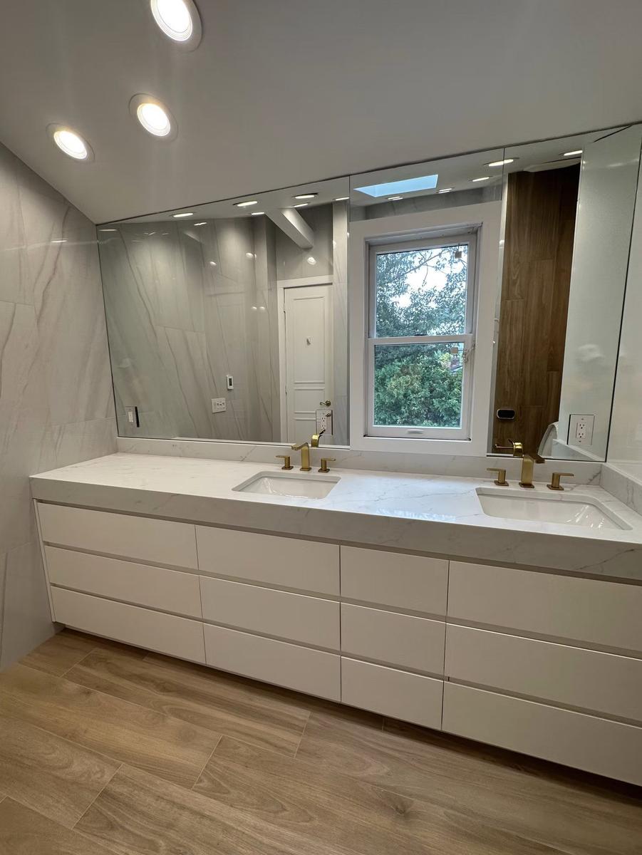 Custom walnut floating vanity with undermount sink and stone countertop in luxury bathroom