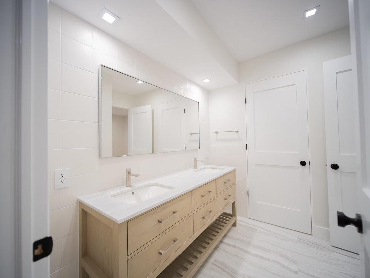 Master bathroom with freestanding soaking tub and custom tile work in modern farmhouse
