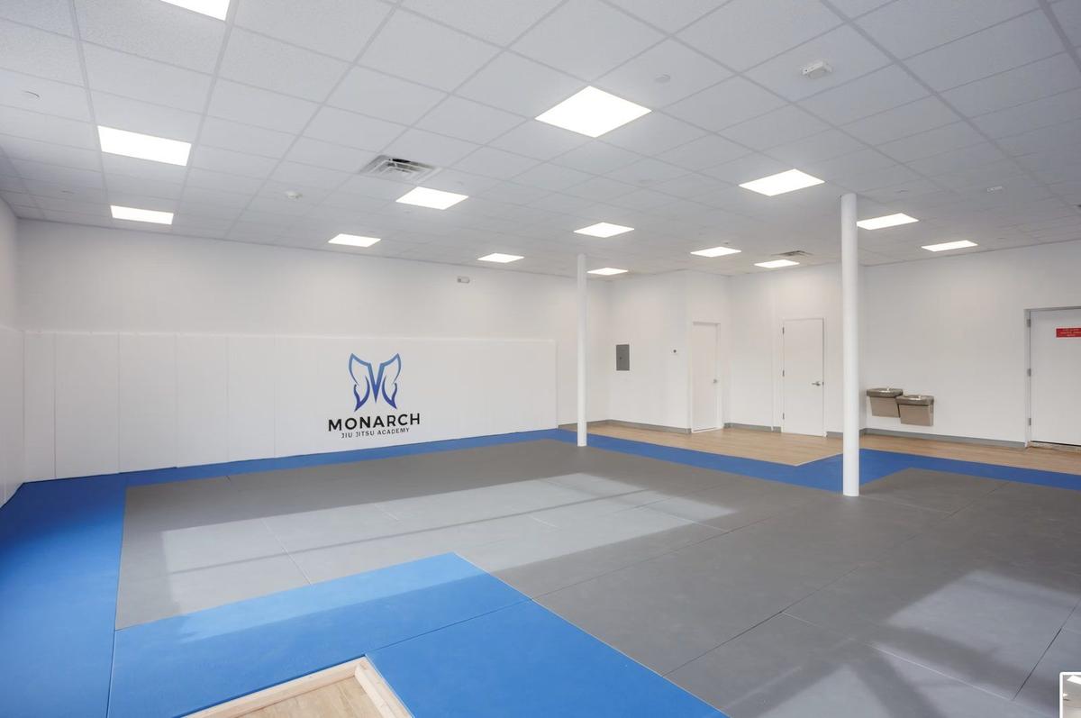 Custom logo mat installation on training floor at Monarch Jiu-Jitsu Academy