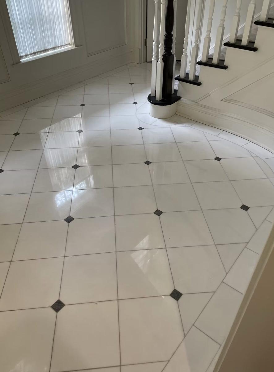 Custom foyer tile installation with decorative pattern in estate home entrance